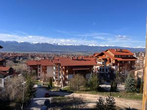 a city with buildings and mountains in the background at Mirabell Apartment Bansko - Mountain View & Fireplace in Bansko