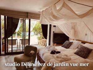 a bedroom with a large bed with a canopy at le lodge Saint Clair in Sète