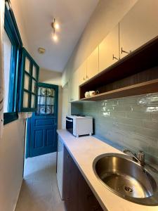 a kitchen with a sink and a microwave at LITHARI PENTHOUSE in Alikanas