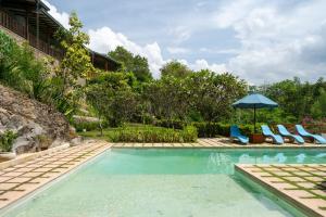 a swimming pool with chairs and an umbrella at Rukgala Retreat in Digana +62 photos