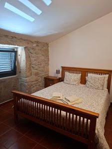 a bedroom with a bed with two books on it at CabrilHome - AL Gerês in Cabril