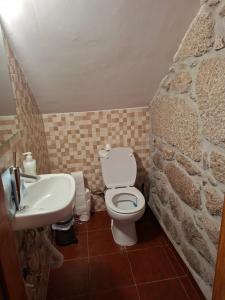 a bathroom with a white toilet and a sink at CabrilHome - AL Gerês in Cabril +56 photos