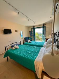 two green beds in a room with a window at LITHARI PENTHOUSE in Alikanas