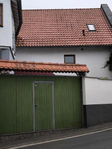 a house with a green garage with a red roof at Ferienwohnung Weyer in Villmar