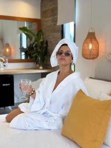 a woman sitting on a bed holding a wine glass at Alquimia House tu refugio en Santa Ana in Corrientes +67 photos