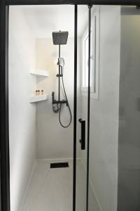 a bathroom with a shower with a glass door at kleris apartment 3 in Tinos