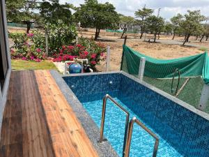 a swimming pool with a hammock in a yard at Auravista in Pālghar