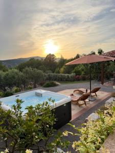 a backyard with a pool and an umbrella and a table at STARA KUĆA - old stone house in Grižane