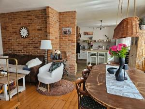 a living room with a table and a brick wall at Vila RAMI in Donja Poljana