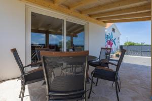 a patio with a table and chairs on a porch at Villa Romana in Bibinje