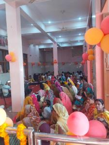 a group of people sitting in a room with balloons at Mauni Ashram in Prayagraj