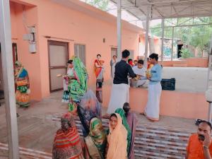 a group of people standing outside of a building at Mauni Ashram in Prayagraj