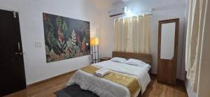 a bedroom with a bed with a painting on the wall at Velora Stays - Nr Airport & World trade center in Pune +2 photos