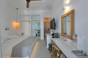 a bedroom with a large bed and a mirror at kleris apartment 3 in Tinos
