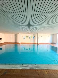 a large swimming pool with a large ceiling at Sorpesee Stay in Sundern +6 photos