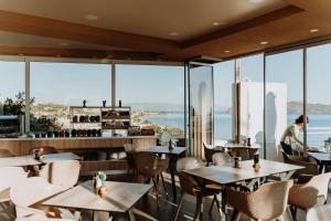 a restaurant with tables and chairs and a view of the ocean at Renieris Hotel in Stalos