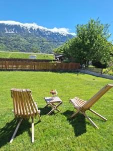 two chairs and a picnic table in a yard with mountains at Tilka`s house in Blejska Dobrava