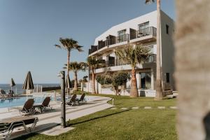a view of a resort with palm trees and a pool at Renieris Hotel in Stalos