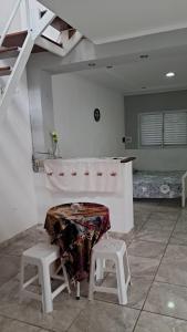 a room with a table and two stools in it at Casa céntrica de 2 dormitorios in Cañada de Gómez