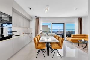 a kitchen and dining room with a table and chairs at Apartman A Villa Legato in Tučepi
