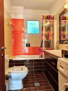 a bathroom with a toilet and a tub and a sink at Zoe By The Sea in Paralia Katerinis