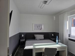 a bedroom with a bed and a table and a desk at Privatunterkunft Bingum in Leerort