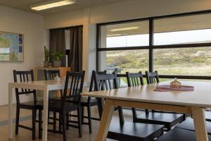 a dining room with two tables and chairs and a window at FarNorth Hostel in Bakkafjörður