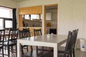 a dining room with a white table and chairs at FarNorth Hostel in Bakkafjörður +20 photos
