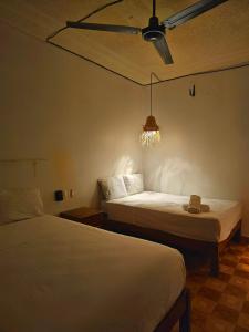 a bedroom with two beds and a ceiling fan at Casa Kal'i in Brisas de Zicatela