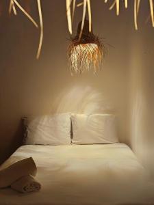 a bedroom with a bed with white sheets and some grass at Casa Kal'i in Brisas de Zicatela
