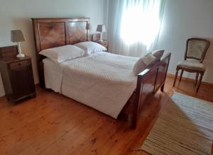 a bedroom with a large bed and a chair at Dal Grof in Tualis
