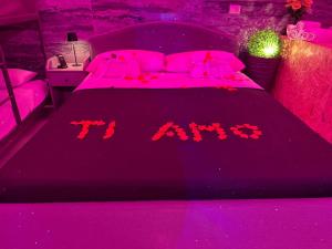 a bedroom with a bed with pink lights on it at Affittacamere Gess in Montalto Uffugo