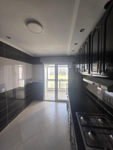 a large kitchen with black counters and a large window at Apartment Stunning Panoramic View in Tétouan +10 photos