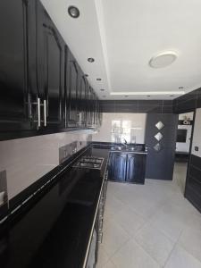 a kitchen with black cabinets and a white tile floor at Apartment Stunning Panoramic View in Tétouan