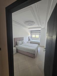 a white bedroom with a bed and a ceiling at Apartment Stunning Panoramic View in Tétouan