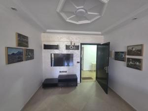 a living room with a door and a wall with a television at Apartment Stunning Panoramic View in Tétouan