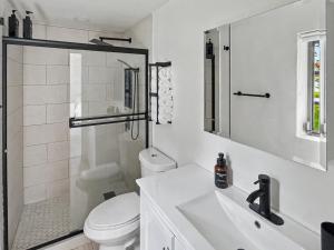 a white bathroom with a toilet and a sink at Casa Arya in Howard