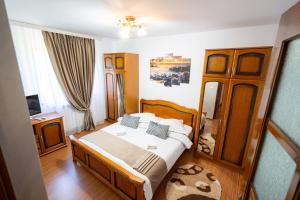 a bedroom with a bed and a wooden cabinet at Casa Ursuleasa in Ciumîrna
