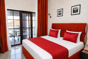a bedroom with a large bed with red pillows at Delmar Boutique Buzovna in Mekhrably