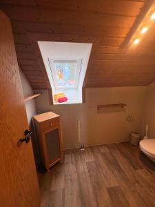 a bathroom with a toilet and a window in a attic at Ferienwohnung am Feistelholz in Wernberg-Köblitz +17 photos