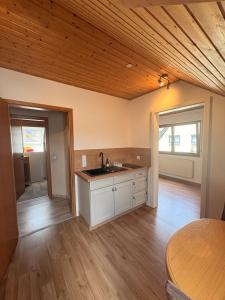 a kitchen with a wooden ceiling and a table at Ferienwohnung am Feistelholz in Wernberg-Köblitz