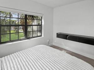 a white bedroom with a bed and a window at Casa Arya in Howard