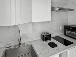 a kitchen counter with a sink and a microwave at Casa Arya in Howard