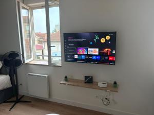 a flat screen tv on the wall of a bedroom at Cocon de la gare in Montélimar