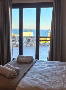 a bedroom with a bed with a view of the ocean at PetraCasa Luxury Villa in Azolimnos Syros +73 photos