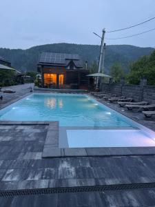 a large swimming pool in front of a house at Майя in Mykulychyn