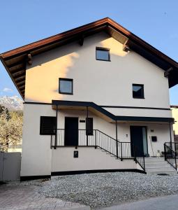 a white house with black doors and a balcony at Ferienwohnung Natters - Your vacation base in Innsbruck
