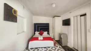a bedroom with a bed with red and white pillows at Olympia GuestHouse in Kempton Park