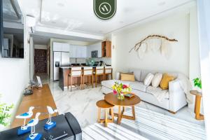 a living room with a couch and a table at 3BR Condo Right Next to the Beach - Pool - Palapa in Nuevo Vallarta