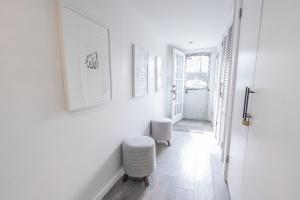 a hallway with white walls and white stools at Minimal 1bed APT basement with free parking in Yonkers +23 photos